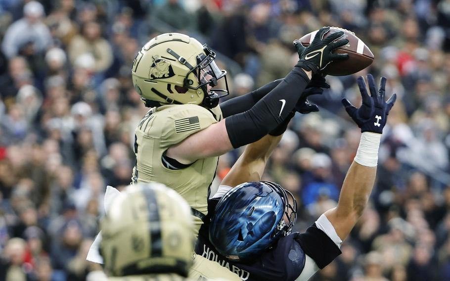 Army's Max DiDomenico goes over Navy wide receiver Cody Howard to intercept a pass during the first quarter of an NCAA football game at Gillette Stadium Saturday, Dec. 9, 2023, in Foxborough, Mass.