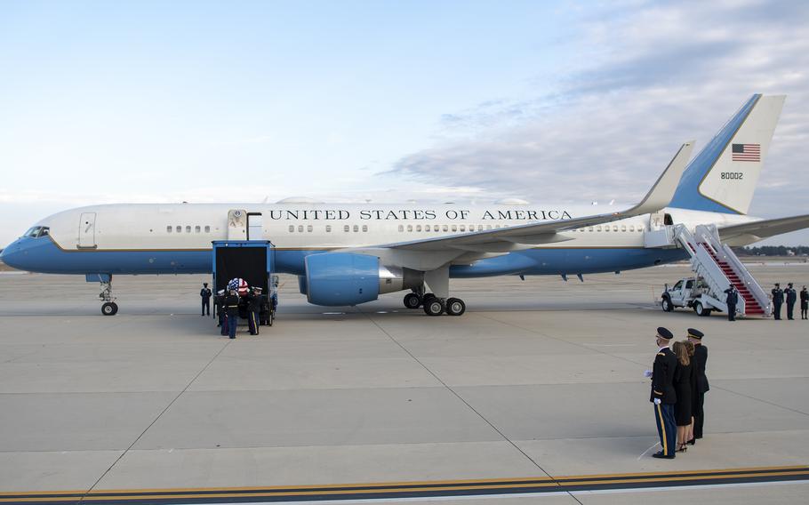 Members of a joint honor guard load the casket of WWII veteran and former Kansas Sen. Bob Dole onto a truck beside an Air Force transport plane at Joint Base Andrews, Md., on Friday, Dec. 10, 2021. At right looking on are Chairman of the Joint Chiefs of Staff Gen. Mark Milley, far right next to Dole's wife Elizabeth, the Doles' daughter Robin and Army Maj. Garrett Beer.