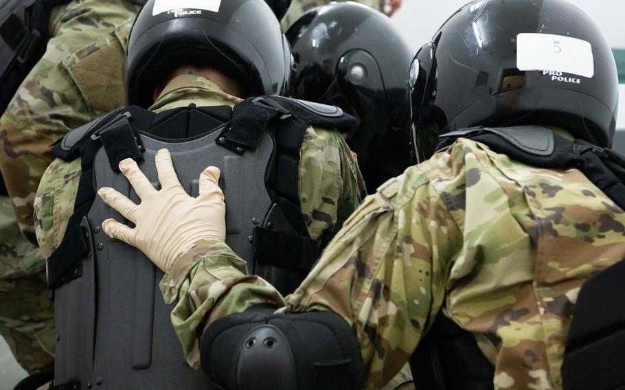 Guards practice removal of an unruly prisoner from a cell Tuesday, Nov. 22, 2022, at the U.S. military's jail in Sembach, Germany.