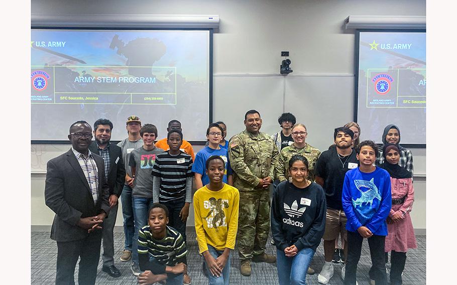At the end of the second week of engineering summer camp, participating campers and faculty and staff at The University of Texas Permian Basin pose for a photo with Army personnel.
