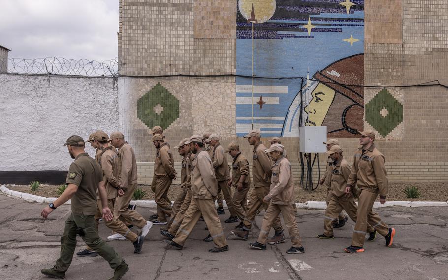 Prisoners walk in a prison yard in Ukraine during a media event last month related to a new law allowing the recruitment of some convicts for the military. 
