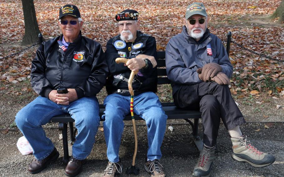 Three Vietnam veterans relax as they await the start of a Veterans Day ceremony at the Vietnam Veterans Memorial in Washington, D.C., Nov. 11, 2023.