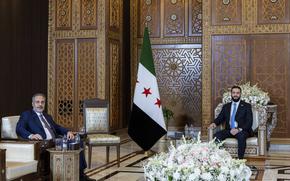In this handout photo released by the Turkish Foreign Ministry press service, Turkish Foreign Minister Hakan Fidan, left, sits with Syria's interim President Ahmad Al-Sharaa, during their meeting in Damascus, Syria, Thursday, Aug. 7, 2025. (Turkish Foreign Ministry via AP)