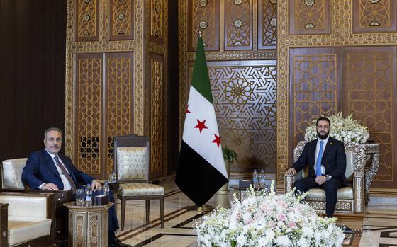 In this handout photo released by the Turkish Foreign Ministry press service, Turkish Foreign Minister Hakan Fidan, left, sits with Syria's interim President Ahmad Al-Sharaa, during their meeting in Damascus, Syria, Thursday, Aug. 7, 2025. (Turkish Foreign Ministry via AP)