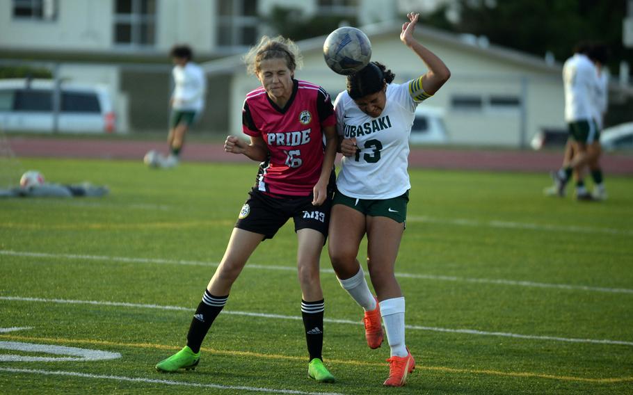 Kadena's Marina Sawyer and Kubasaki's Liyana Solano try to head the ball during Wednesday's Okinawa girls soccer match. The Dragons won 1-0.