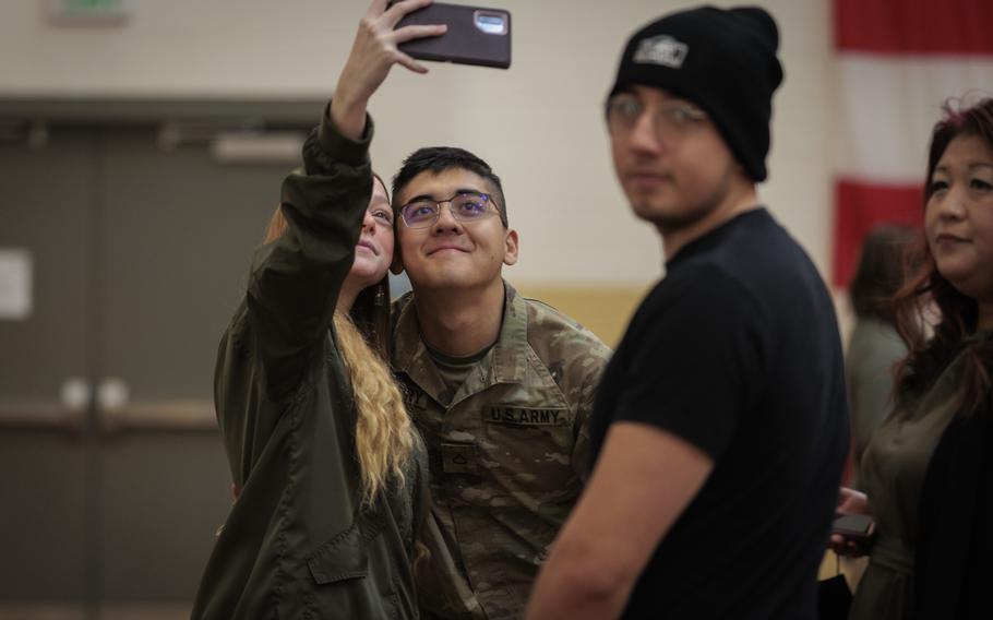 A Washington National Guard soldier with the 506th Military Police Detachment, 420th Chemical Battalion, 96th Troop Command, takes a selfie with a loved one during a ceremony on Joint Base Lewis-McChord, Wash., Oct. 29, 2023. The detachment is deploying to Jordon in support of Operation Spartan Shield.