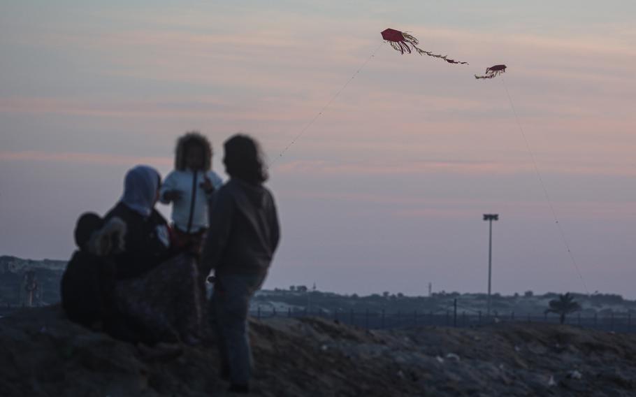 Children fly a kite at a makeshift tent camp for displaced Palestinians in Rafah, southern Gaza Strip, on Sunday, Feb. 11, 2024.