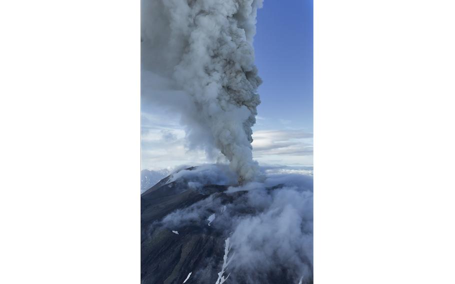 Plumes of smoke and ash rise high into the sky.