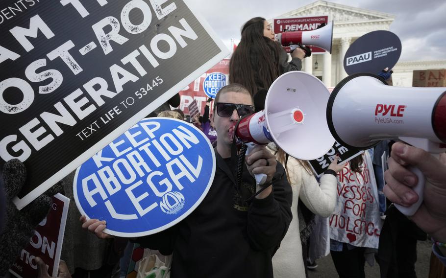An abortion rights protestor, center, uses a megaphone as anti-abortion demonstrators rally outside the U.S. Supreme Court during the March for Life, Friday, Jan. 20, 2023, in Washington.
