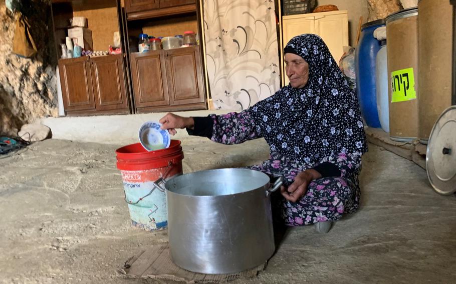 Yusara al Najar makes labneh cheese in the cave where her family of 10 has been living since their home was demolished. Her grandparents dug the cave decades ago, a traditional living arrangement in the area. Families now use them as kitchens, extra space and refugees when the army knocks down their house.