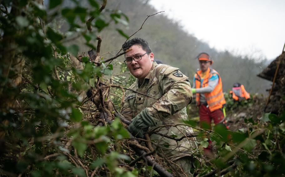 Spc. Lindsey Bakthy clears undergrowth to protect an old castle wall in St. Goar, Germany, on Feb. 23, 2023. Bakthy was one of about two dozen volunteers from the U.S. and German militaries who supported the clearing project. 