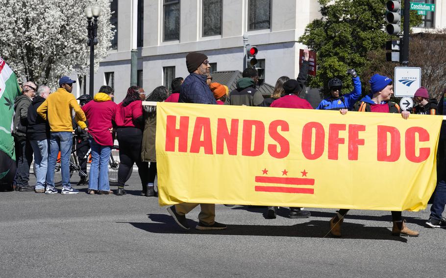 Demonstrators hold a banner during a protest in front of the Dirksen Senate Office Building, Wednesday, March 8, 2023, on Capitol Hill in Washington. Protestors rallied against a Republican-sponsored resolution blocking new District of Columbia laws that would overhaul how the nation’s capital prosecutes and punishes crime.