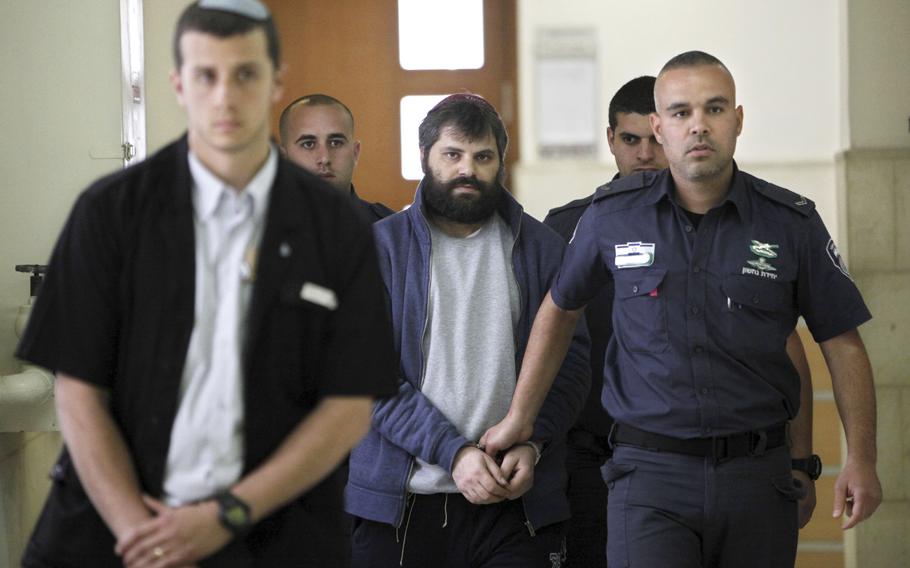 Yosef Haim Ben David, center, arrives at court in Jerusalem on March 22, 2016, during his murder trial in the death of a 16-year-old Palestinian boy. An Israeli group raising funds for Jewish radicals convicted in some of the country’s most notorious hate crimes, including Ben David, is collecting tax-exempt donations from Americans, according to an investigation by the AP and the Israeli investigative platform Shomrim.