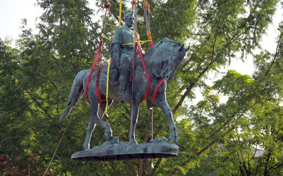 A statue of Confederate Gen. Robert E Lee in Charlottesville, Va., is lifted off its pedestal in Market Street Park on July 10, 2021. A lawsuit will determine whether the statue can be melted down.