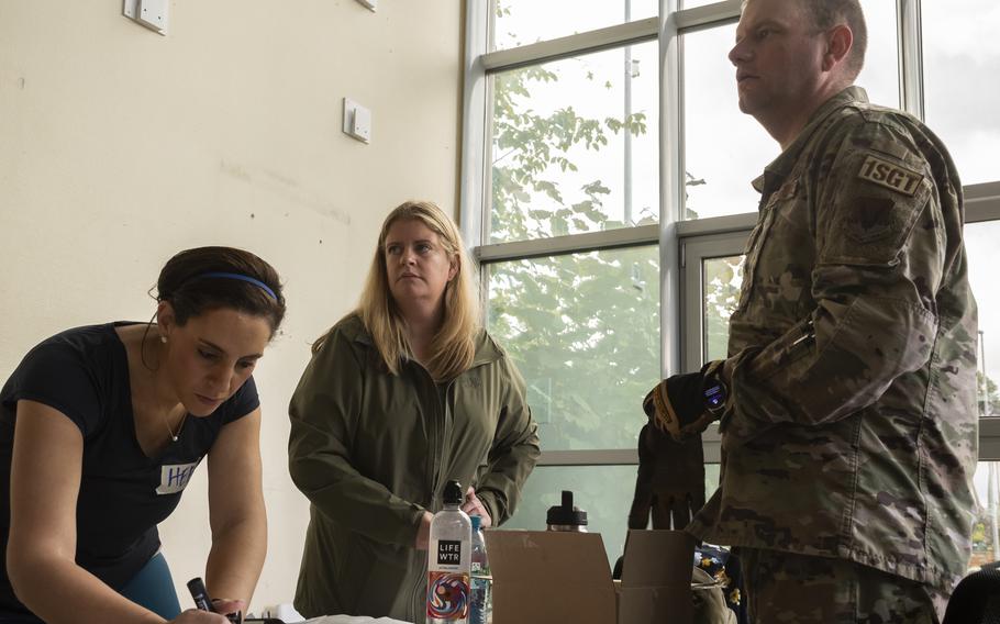 Heba Abdelaal, Heather Mecsko, and Master Sgt. Mitch Meis help organize a donation drive for Afghan refugees at Ramstein Air Base on Aug. 26, 2021.