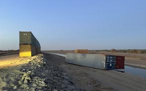 This photo provided of Univision Arizona shows empty shipping containers toppled over Sunday overnight on the Mexico-US international borderline in Yuma, Ariz., on Monday, Aug. 16, 2022. 