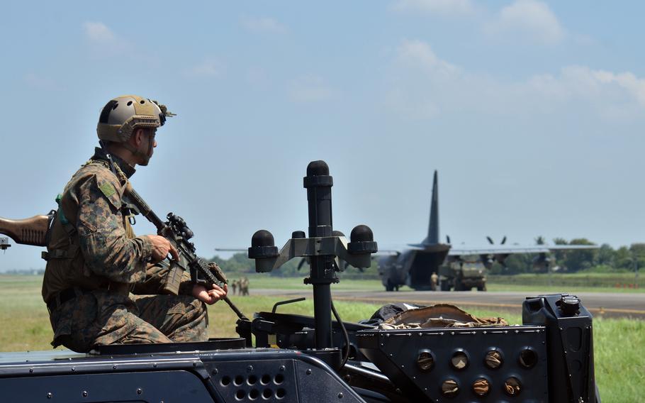 A U.S. Marine stands watch as a U.S. Army High Mobility Artillery Rocket System, or HIMARS, drives off an MC-130J Commando II at Sultan Mahmud Badaruddin II International Airport in Palembang, Indonesia, Tuesday, Aug. 9, 2022. 