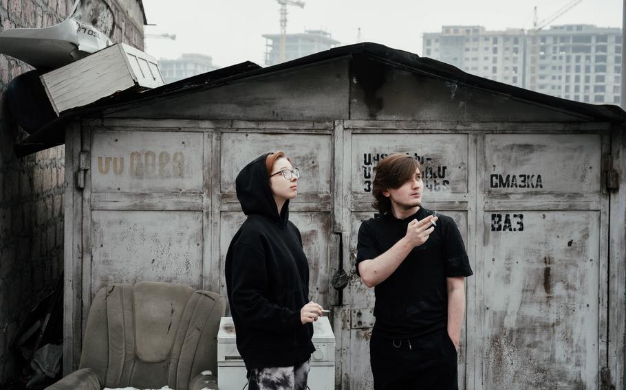 Ekaterina, 19, and Yaroslav, 21, smoke cigarettes near a shelter provided by Kovcheg, a Russian immigrant support group, on Feb. 1 in Yerevan, Armenia.