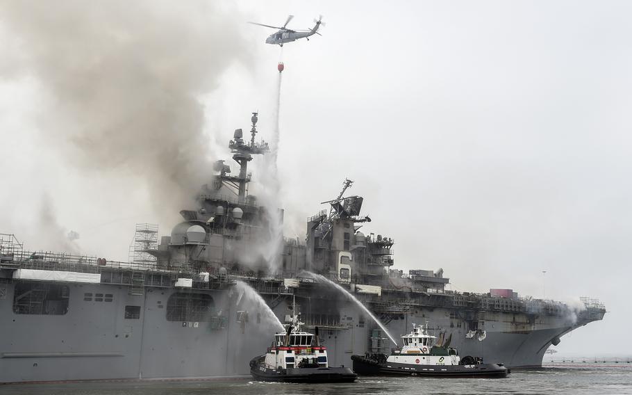 Federal firefighters and a helicopter from Helicopter Sea Combat Squadron 3 battle a blaze aboard the amphibious assault ship USS Bonhomme Richard at Naval Base San Diego, July 13, 2020. 