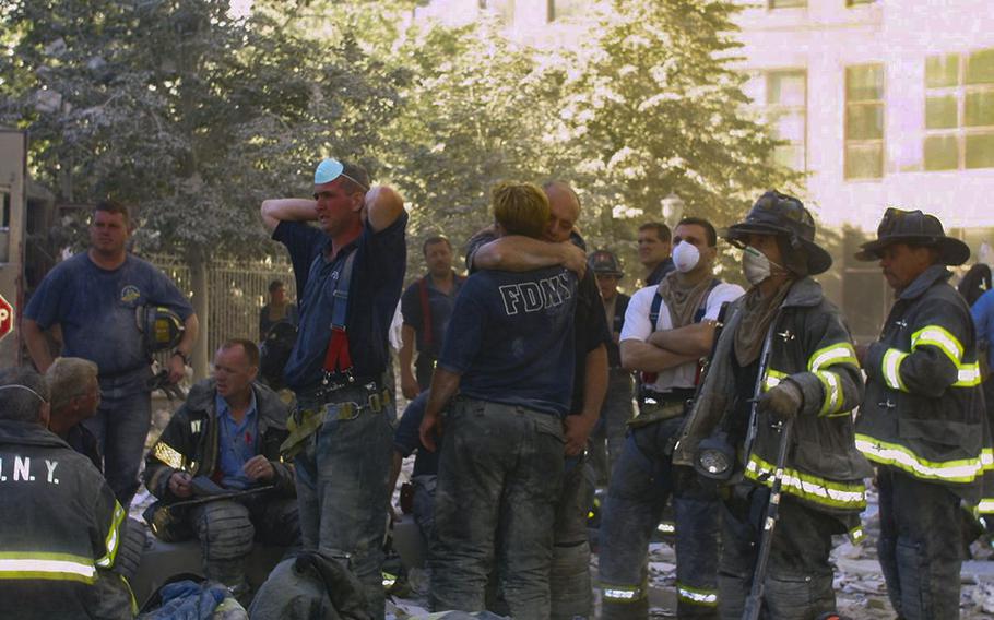New York City firefighters hug each other during rescue operations at the World Trade Center on Sept. 11, 2001. Three hundred and forty-three firefighters died trying to save people during the harrowing attacks that day. Since then, hundreds more have died from ground zero-related illnesses. 