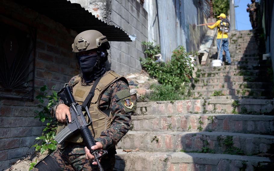 Inmates of the “La Esperanza” prison escorted by guards and soldiers paint over graffiti linked to the Mara Salvatrucha gang, at the 22 de Abril community, in Soyapango, on the eastern outskirts of San Salvador, during an operation to take back gang-controlled neighborhoods on April 7, 2022. 