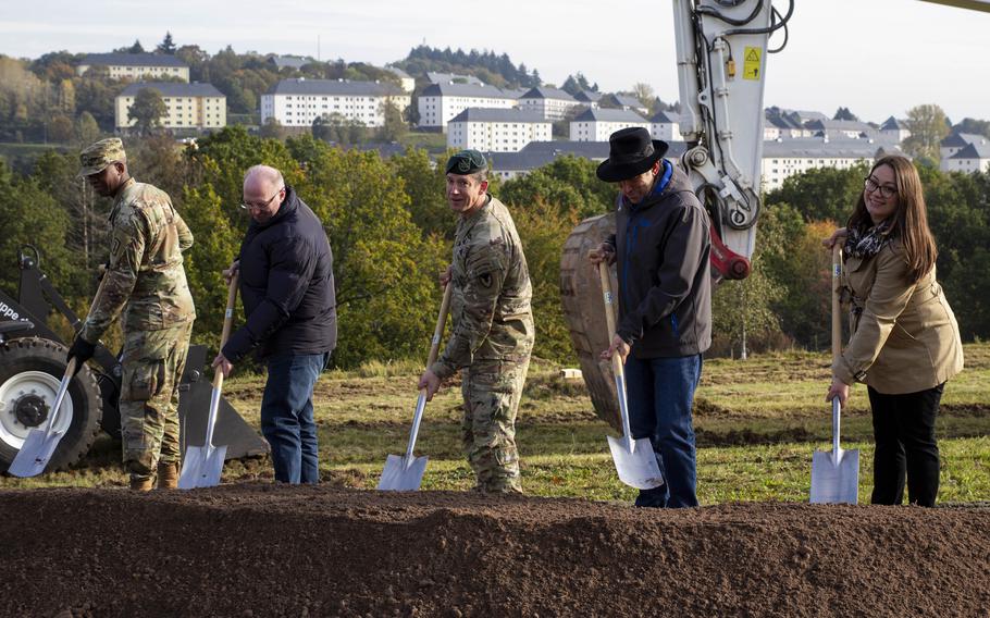 Dignitaries including Col. Reid Furman, the Rheinland-Pfalz garrison commander, center, break ground at the Wetzel Kaserne housing area on construction of 64 new residence units Oct. 18, 2023, in Baumholder, Germany. In the background is Smith Barracks, where more new housing and a new Army lodge are to be built.