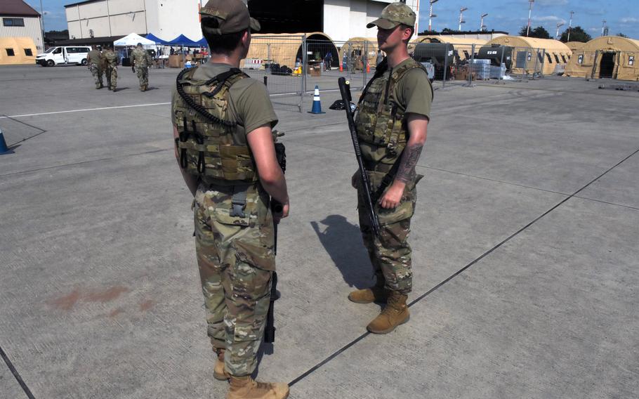 Airmen 1st Class Isaiah Byrd, left, and Turner Jackson, secure the entrance to temporary living facilities set up for Afghan evacuees on the flight line at Ramstein Air Base, Germany, Aug. 21, 2021. Members of the 86th Security Forces Squadron are among numerous airmen, soldiers and volunteers pulling long hours to support thousands of evacuees on base.