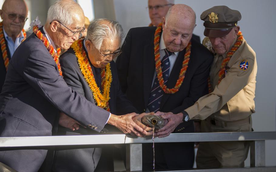 Shiro Wakita (left to right), former WWII Imperial Japanese Navy pilot; Dr. Hiroya Sugano, director general of the Zero Fighter Admirers Club; Jack Detour, former colonel and WWII Army Air Force B-25 pilot; Jerry Yellin, former captain and WWII Army Air Force P-51 pilot, pour bourbon whiskey at the sixth annual Blackened Canteen ceremony at the USS Arizona Memorial during the 75th Commemoration of the attacks on Pearl Harbor. 