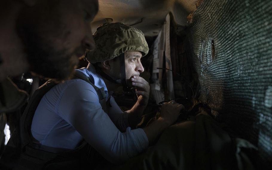 Ukrainian President Volodymyr Zelenskyy looks at a front-line position from a shelter as he visits eastern Ukraine in an undated photo. According to reports on Friday, April 15, 2022, Ukrainian officials are using facial recognition technology on dead or captured Russian soldiers and contacting their families.