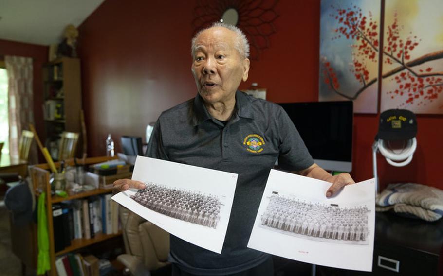 Seiki Oshiro holds photos of two graduating classes of the Military Intelligence Service Language School from the 1940s.