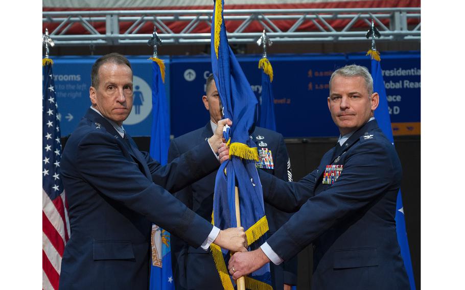 Lt. Gen. Shaun Q. Morris, Air Force Life Cycle Management Center commander, passes the 88th Air Base Wing guidon to Col. Christopher Meeker during a change of command ceremony July 7, 2022, inside the National Museum of the U.S. Air Force at Wright-Patterson Air Force Base, Ohio. 