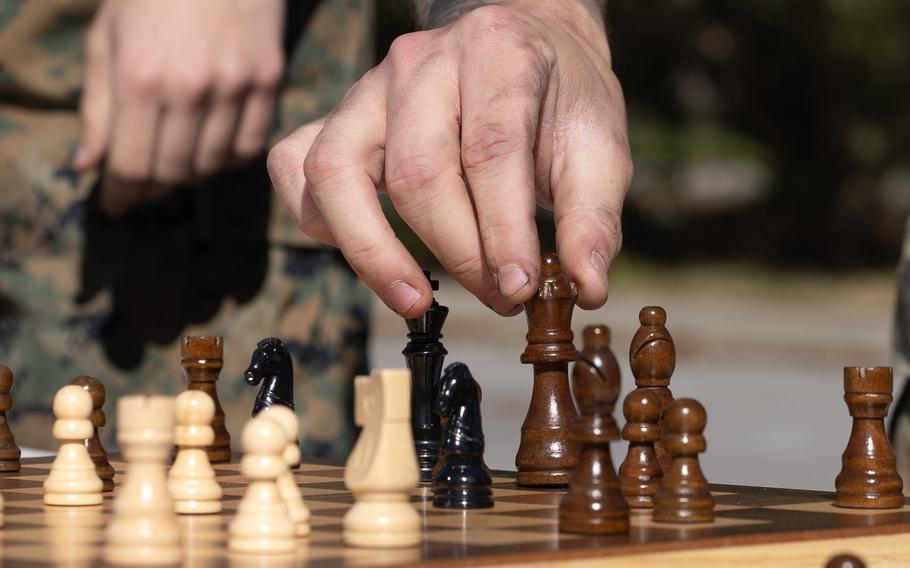 A hand moves a chess piece