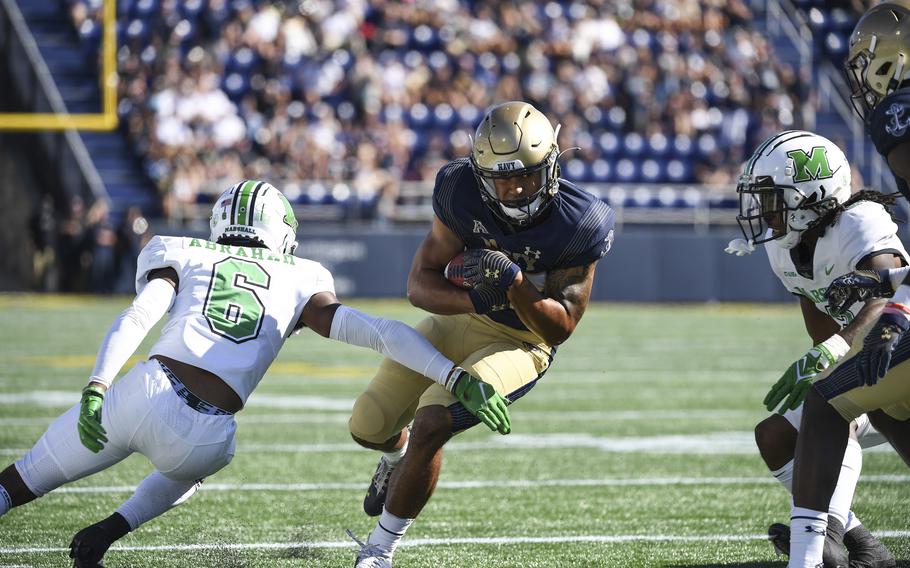 Navy wide receiver Jayden Umbarger runs the ball against Marshall defensive back Micah Abraham, left, during the first half of an NCAA college football game, Saturday, Sept. 4, 2021, in Annapolis, Md.