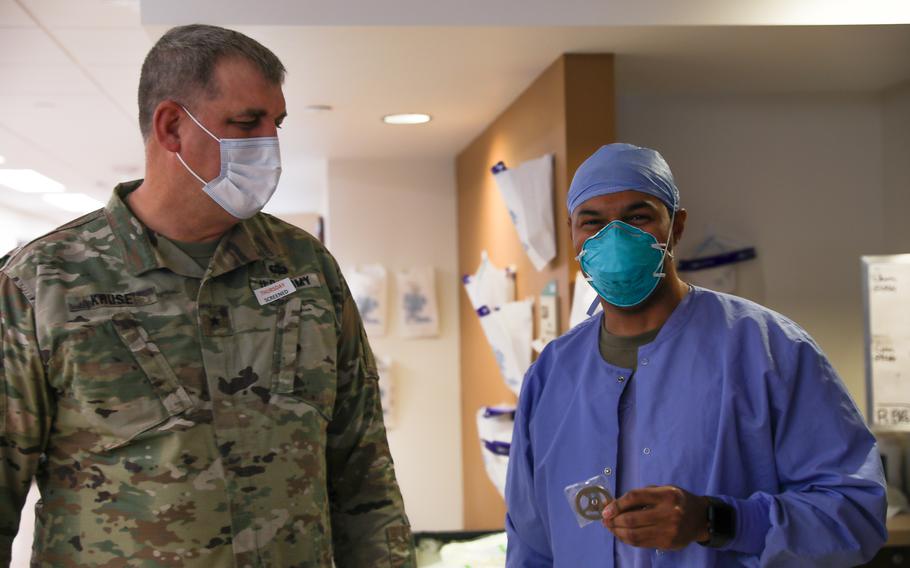 Army Brig. Gen. Lowell Kruse, assistant adjutant general of the Minnesota National Guard, stands with Air Force Capt. Edwin Clark, a clinical nurse assigned to a medical response team deployed to St. Cloud, Minn., on Jan. 20, 2022. The medical response team is deployed to the hospital in support of the continued Defense Department coronavirus response operations to help communities in need. 