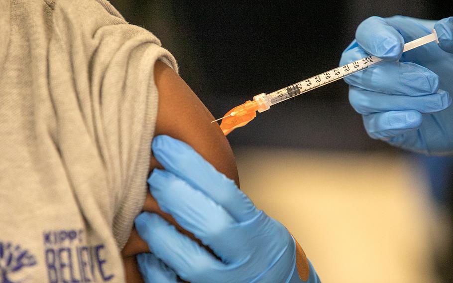 Medical personnel vaccinate students at a school in New Orleans on Tuesday, Jan. 25, 2022. 