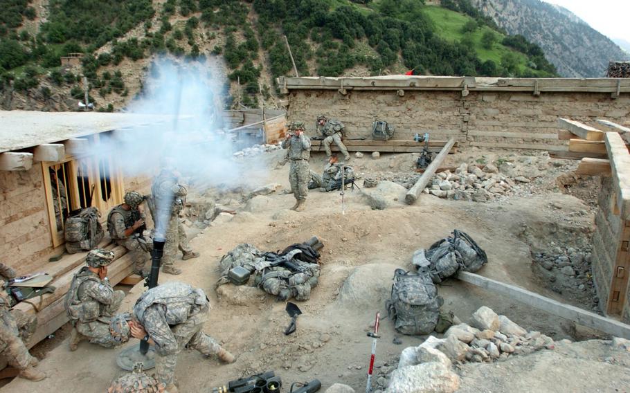 U.S. Army Soldiers with 1st Battalion, 32nd Infantry Regiment, 10th Mountain Division, fire mortar rounds at suspected Taliban fighting positions during Operation Mountain Fire, in the village of Barge Matal in eastern Nuristan province, Afghanistan in July 2009.