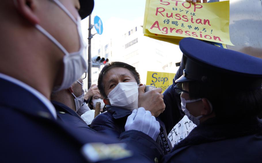 Japanese police block anti-war protesters from reaching the Russian embassy in Tokyo, Friday, Feb. 25, 2022.