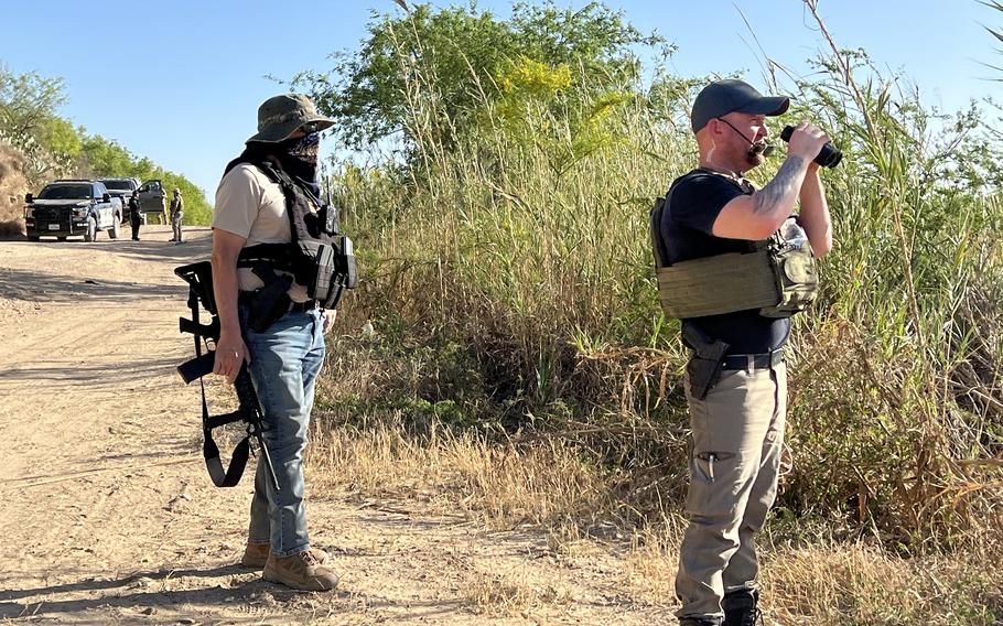 Patriots for America leader Sam Hall, right, patrolling as members conferred with local law enforcement.