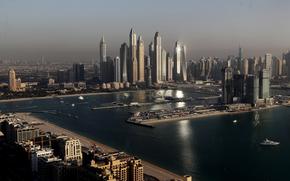 FILE - Luxury towers that dominate the skyline in the Dubai Marina district, center, and the new Dubai Harbor development, right, are seen from the observation deck of "The View at The Palm Jumeirah" in Dubai, United Arab Emirates, on April 6, 2021. A senior United Arab Emirates official says the Gulf nation wants a U.N. climate summit it’s hosting later this year to deliver “game-changing results” for international efforts to curb global warming. But UAE diplomat Majid al-Suwaidi said doing so will require having the fossil fuel industry at the table. (AP Photo/Kamran Jebreili, File)