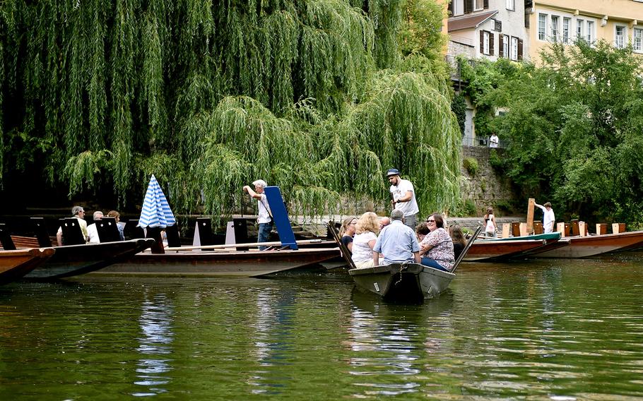 People sit in a small boat floating on a river.