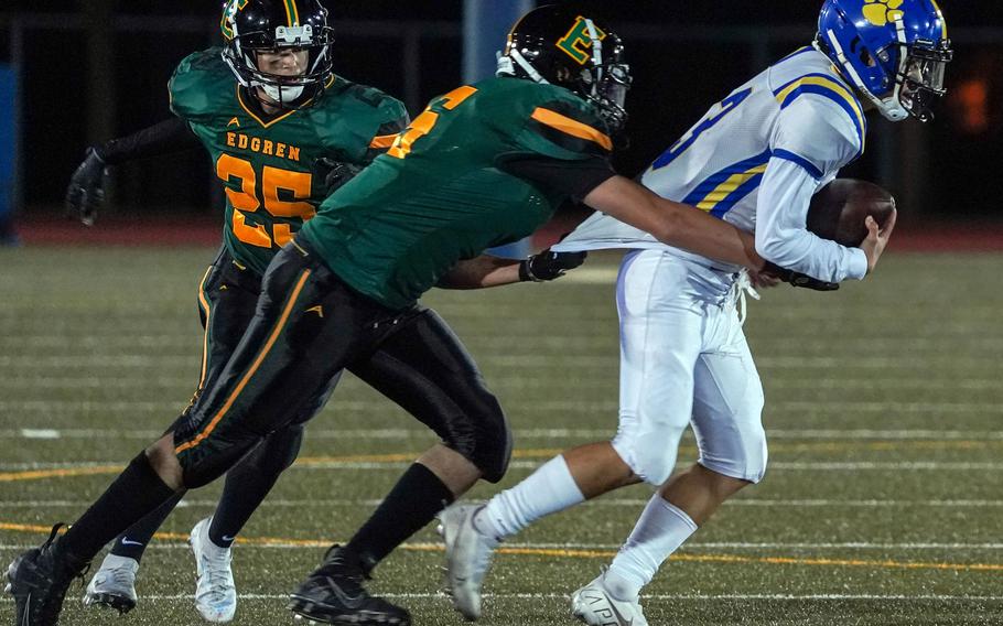 Yokota quarterback Dylan Tomas has his shirt pulled by Edgren's Dennis Nelson as Eagles teammate Santiago Castano looks to help.