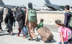 Afghan families walk toward their plane during an evacuation at Hamid Karzai International Airport in Kabul, Afghanistan, Tuesday, Aug. 24, 2021. 