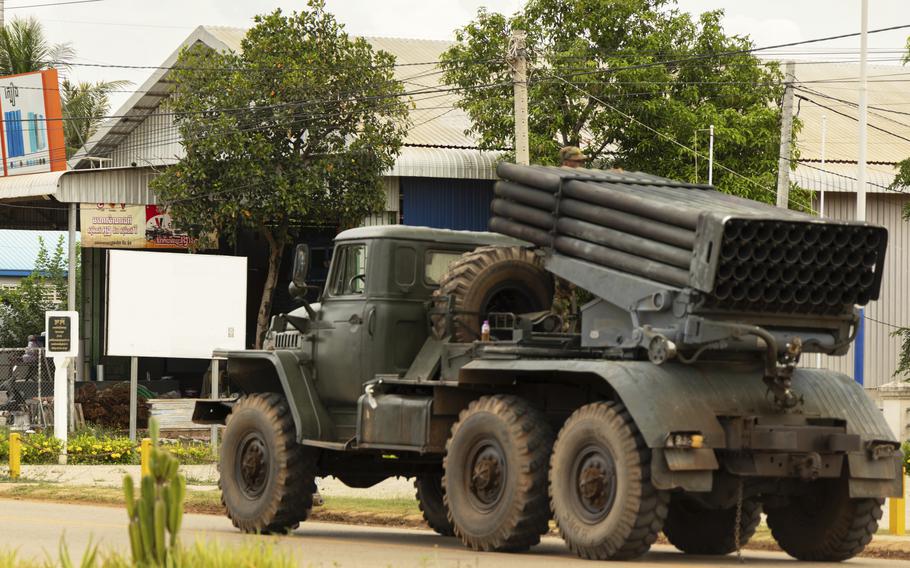 Cambodian military vehicles drive away.