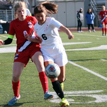 E.J. King's Madelyn Hays tries to keep the ball from Nile C. Kinnick's Bree Withers during Friday's 3-2 Trojan War Cup win by the Red Devils over the Cobras.