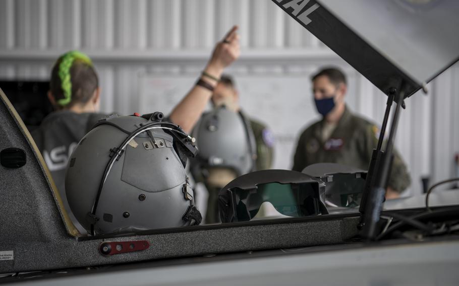 Rina Shkrabova, Red 6 director of hardware design, left, briefs U.S. Air Force Maj. Scott Thorup, Air Combat Command Training Support Squadron Detachment 14 commander, middle, and U.S. Air Force Capt. Garrett Gamble, 7th Operational Support Squadron current operations flight commander, right, about the augmented reality headsets’ designs in Santa Monica, Calif., April 13, 2021. Thorup and Gamble were able to test the AR visors while flying in the Berkut.