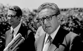 Newly designated Secretary of State Henry Kissinger talks to newsmen during press conference held on the lawn of the western White House in San Clemente, Calif., Aug. 24, 1973. In the background is Gerald Warren, deputy press secretary. (AP Photo)