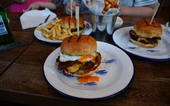 A brunch burger is served at Hmmburger in Newmarket, England, March 7, 2022. The burger comes with a prime beef patty topped with American cheese, smoked streaky bacon, a free-range egg, cooked onion, ketchup and mayo.