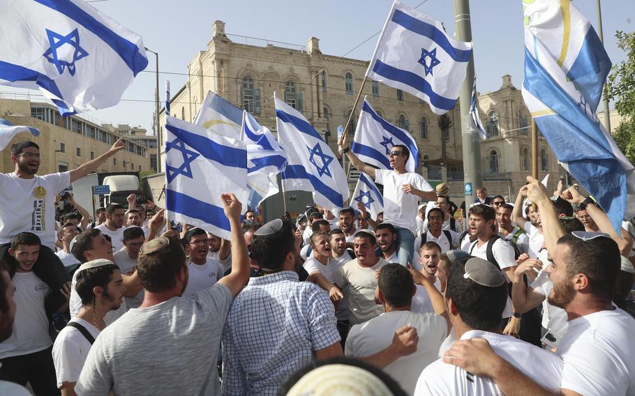 In this May 10, 2021, file photo, Israelis wave national flags during a Jerusalem Day parade, in Jerusalem.
