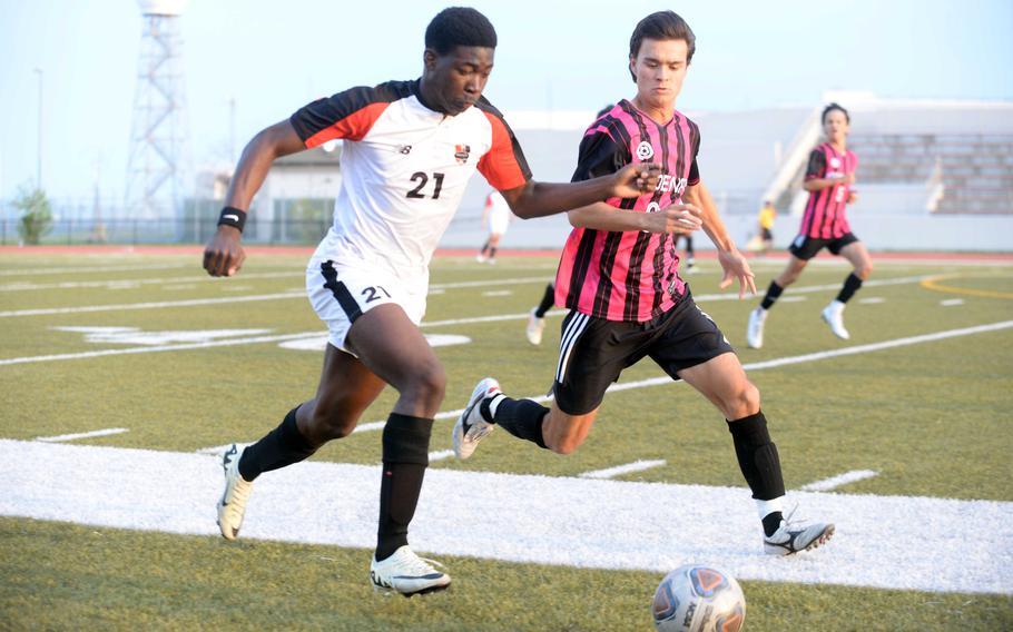 Nile C. Kinnick's Koboyo Awesso and Kadena's Tuck Renquist chase the ball during Friday's DODEA interdistrict boys soccer match. The Panthers won 2-0 in a rematch of last April's Far East Division 1 final, won by the Red Devils at Kinnick 3-2.