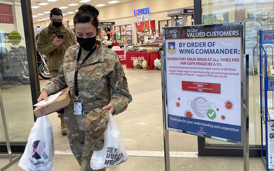 Airmen wear masks as they leave an exchange store at Osan Air Base, South Korea, Friday, Jan. 7, 2022. 